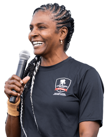 Warrior Tonya Oxendine, holding a microphone while smiling and speaking into it.