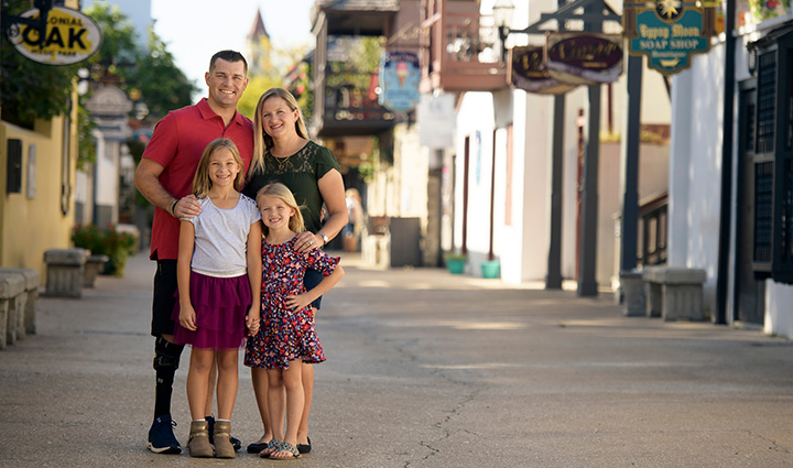 Wounded warrior Mike Larson and his family posing for a photo in the street.