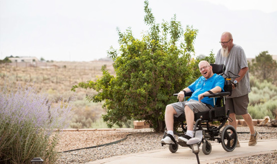 Wounded warrior Erik Schei smiles while his father gently pushes his wheelchair while on a stroll outside.