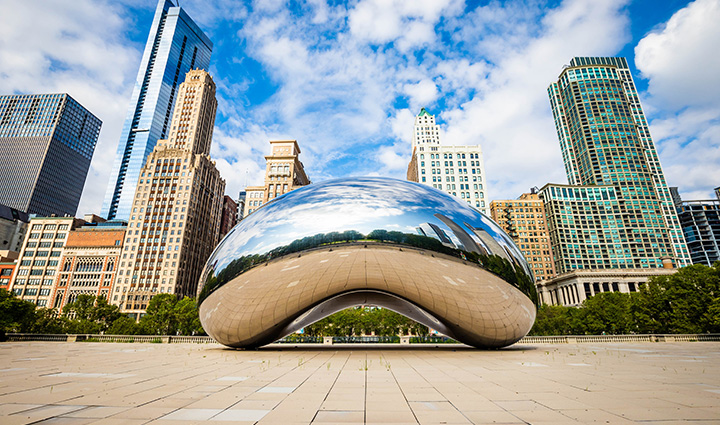 Cloud Gate, also known as “The Bean,” reflects the city skyline and sky in Chicago’s Millennium Park on a partly cloudy day. 