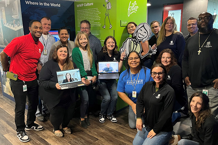 WWP teammates take team photo in front of Mission Experience, an interactive exhibit of WWP's history and mission.