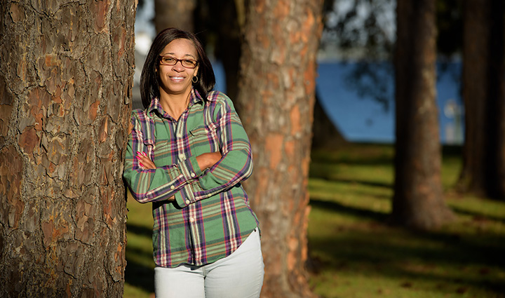 Wounded warrior Lisa Crutch leaning on a tree.