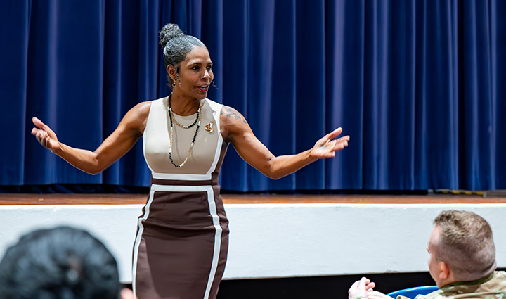 Wounded warrior Tonya Oxendine, dressed in business attire, speaks on stage at a Warriors Speak event.