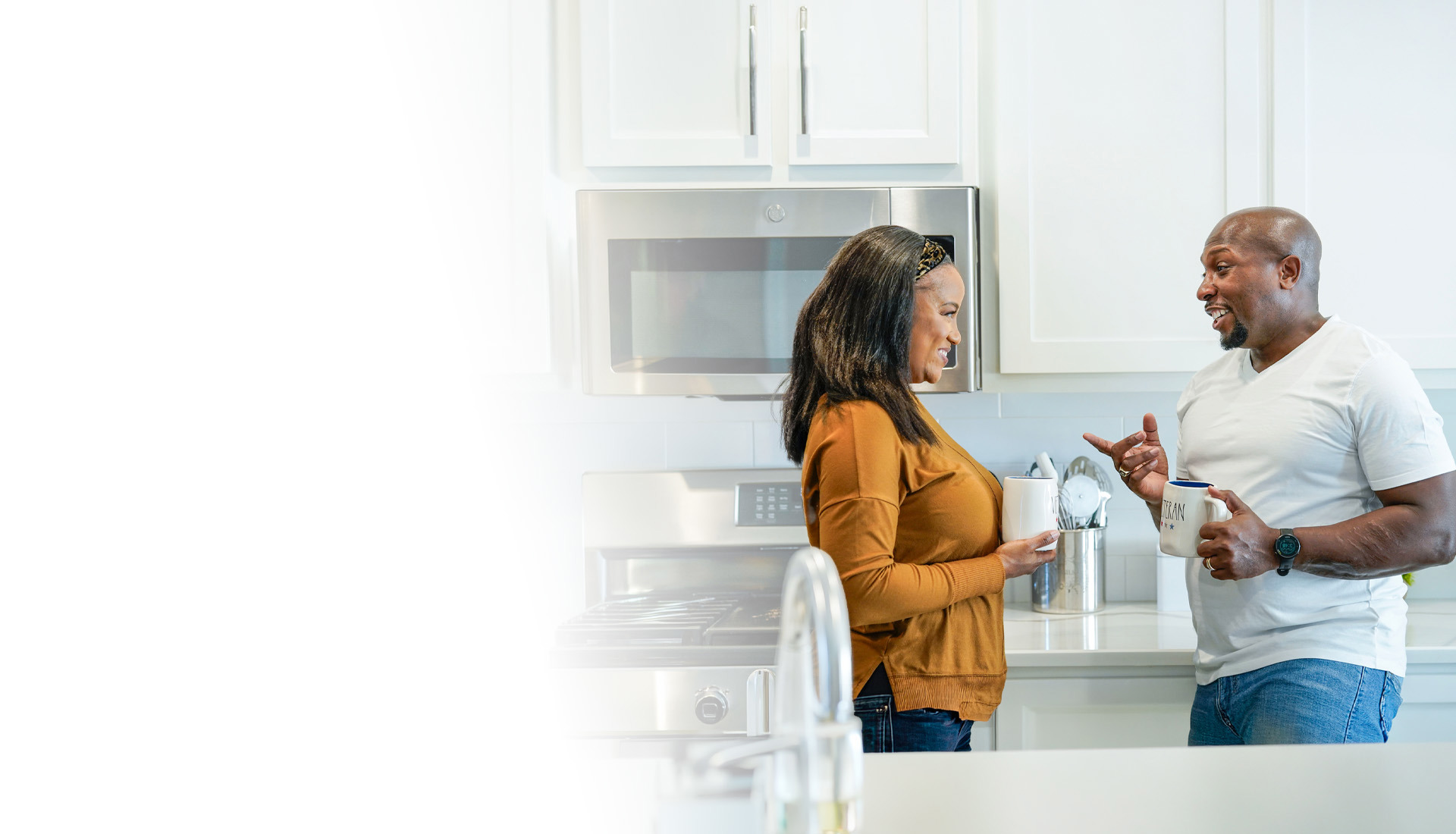 Warrior Melvin Gatewood and his wife, Shalonda, standing in their kitchen smiling and talking while holding coffee mugs.
