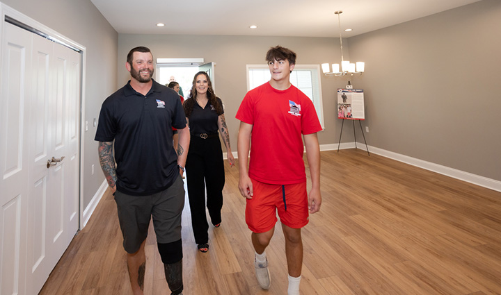 Warrior Sean Karpf walks into his new home smiling with his family.