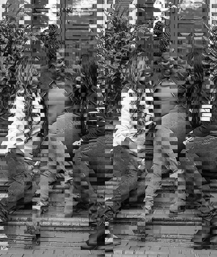 Wounded warriors sit on the steps leading up to the main entrance of a residence,  engaged in conversation.