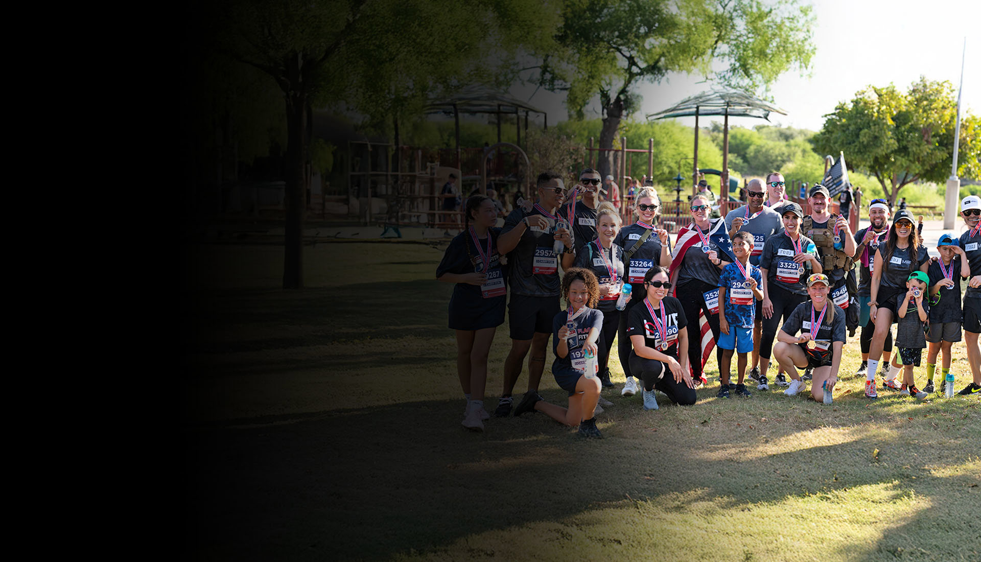 Twenty participants of the Carry Forward 5K gather together, proudly showing off their medals for a group photo.